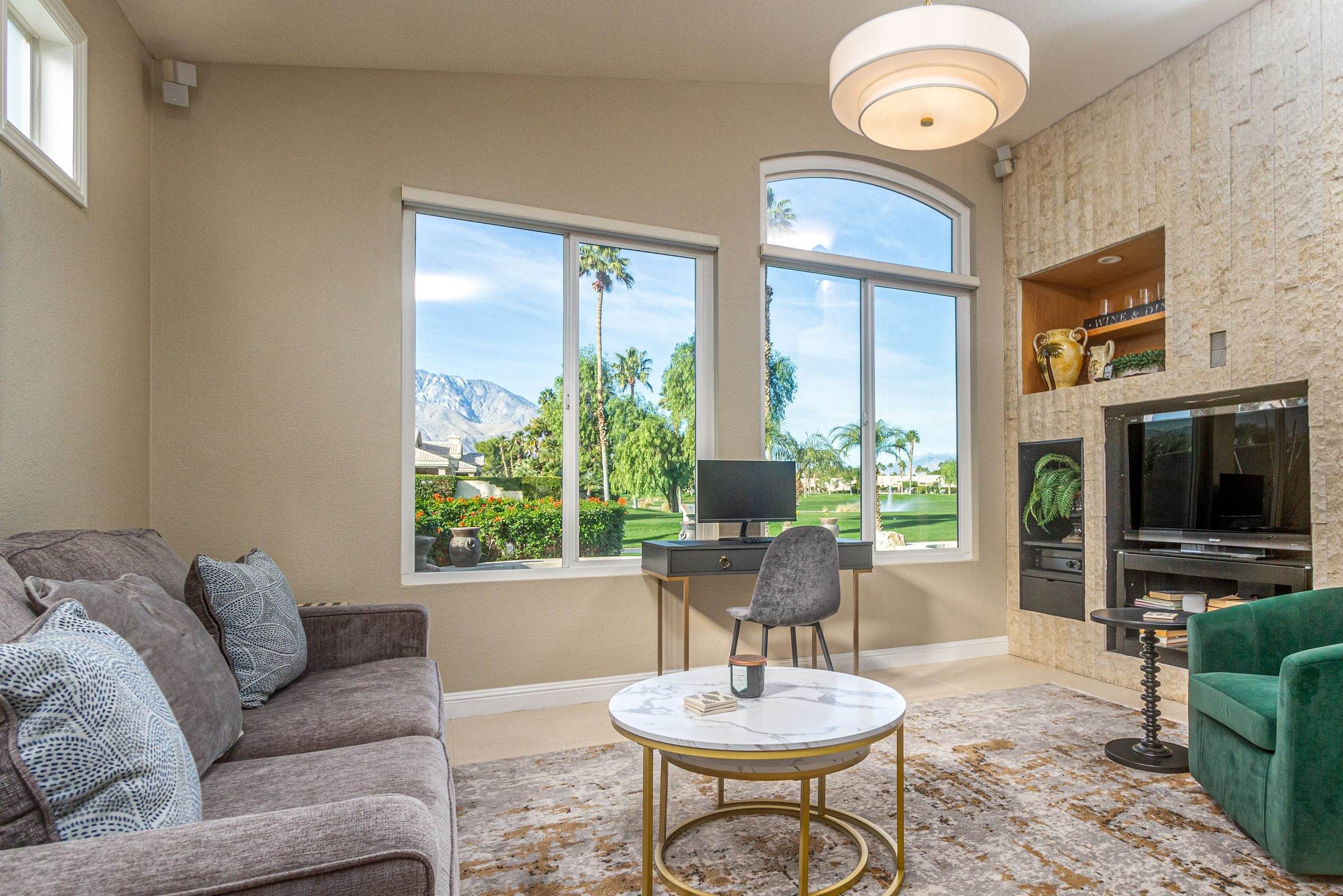 Den with a stone fireplace and TV niche, and a window toward the mountains