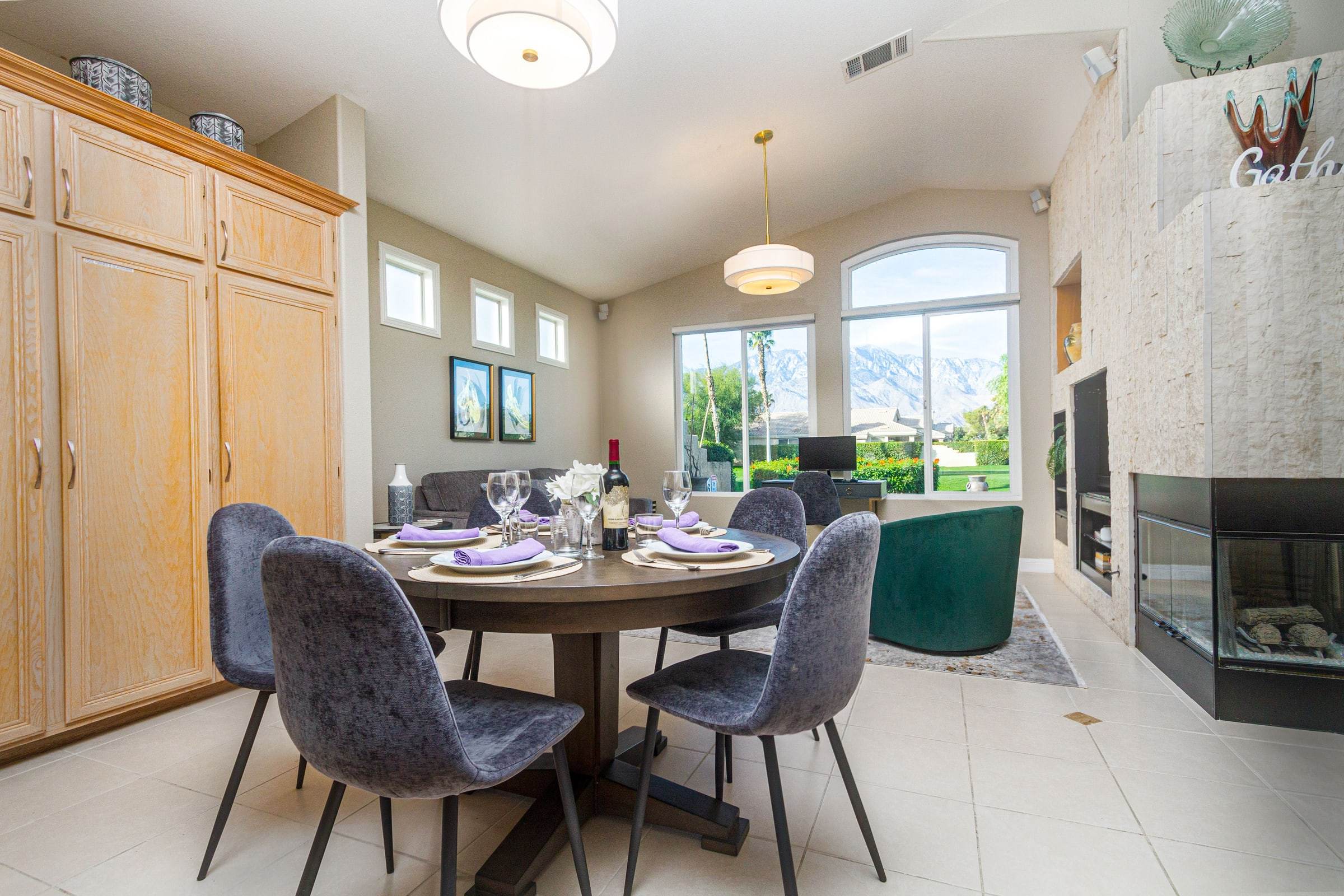 Dining nook table set for dinner beside a see-through fireplace