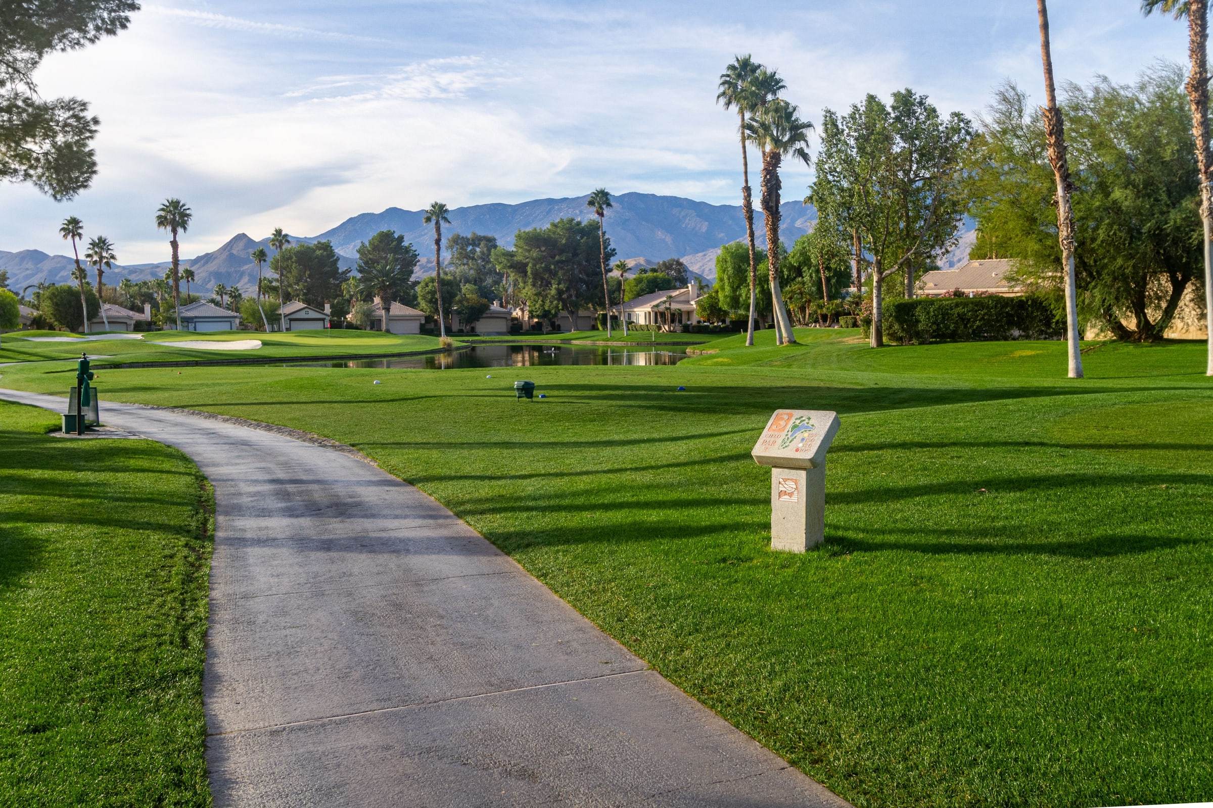 Cart path curving across the golf course toward the mountains