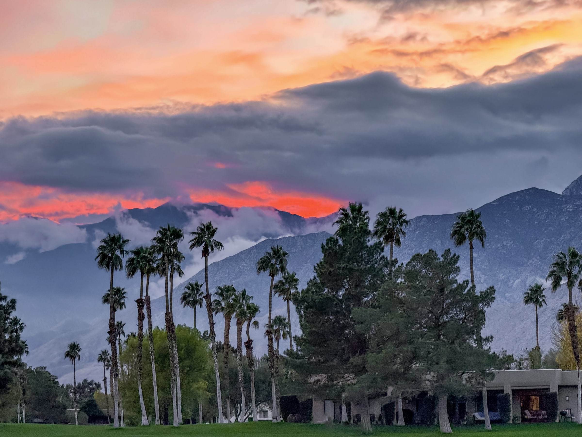 Red sunset over the San Jacinto mountains with palm trees in silhouette